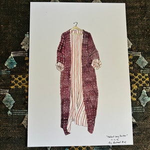 May include: A watercolor painting of a long, burgundy duster with a white and red striped lining. The duster is hanging on a wooden hanger. The painting is titled "Ombre Long Duster" and signed "By: Rachael Rae".