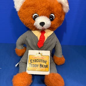 Urso de pelúcia executivo vintage que fala, com cordão funcional, etiqueta da Commonwealth Toy.