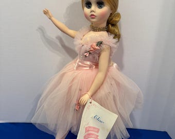 Può includere: Una bambola vintage Madame Alexander Elise in un abito da ballerina di tulle rosa. La bambola ha i capelli biondi, una corona floreale e tiene in mano un'etichetta con scritto "Elise, A Madame Alexander Doll."