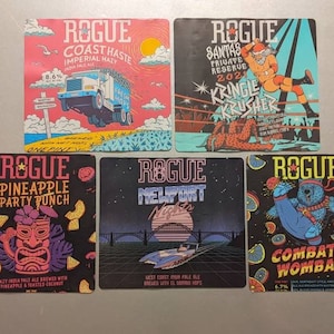 May include: A collection of five Rogue beer coasters. The coasters feature colorful illustrations and text, including "Coast Haste," "Pineapple Party Punch," "Nelport Nights," "Santa's Private Reserve," and "Combat Wombat." Each coaster showcases unique designs and beer names.