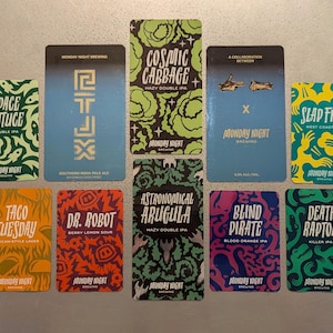 May include: Ten colorful cards with different names and designs. Each card has a different beer name and style, such as "Space Lettuce", "Cosmic Cabbage", "Taco Tuesday", and "Death Raptor".