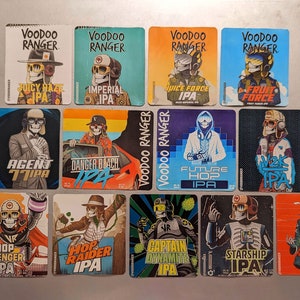 May include: A collection of 12 colorful square stickers featuring a skeleton character in various poses and settings. Each sticker has the text "Voodoo Ranger" and the name of a different beer, such as "Juicy Haze IPA", "Imperial IPA", and "Agent 77 IPA".