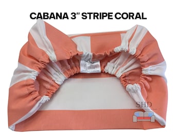 May include: Coral and white striped fabric with the text "CABANA 3" STRIPE CORAL". The fabric is gathered at the edges, suggesting a fitted design. The fabric has a 3-inch stripe pattern. The product is from SHD, a furniture design and store.