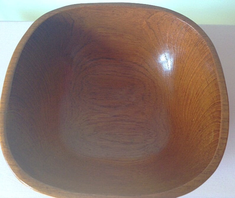 May include: A large, square wooden bowl with a smooth, dark brown finish. The bowl is empty and ready to be used.