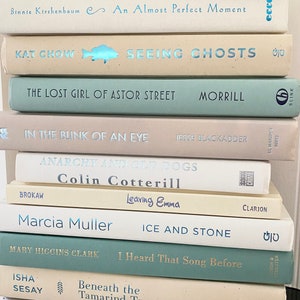 Beautiful coastal books for decor, light neutral beach colors, coastal bookshelf, books for staging neutral home, display book, pretty book