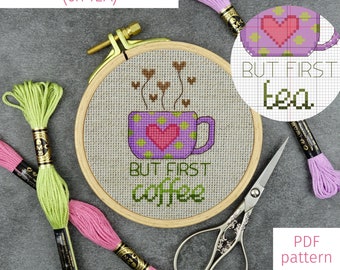 May include: Cross stitch pattern for a coffee mug with the text "But First Coffee" and a heart. The pattern is in a wooden embroidery hoop with pink, green, and purple embroidery floss.