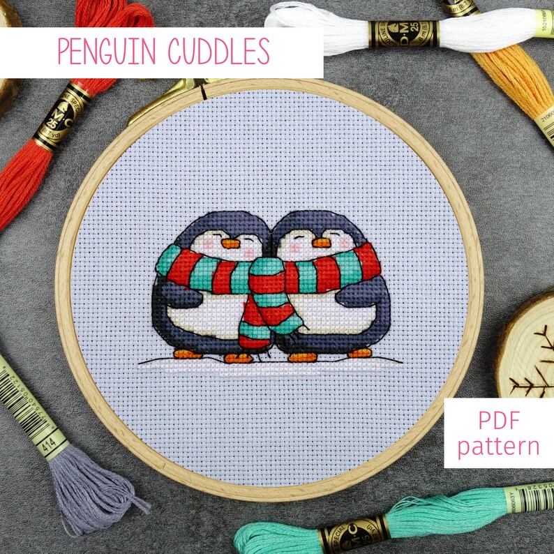 May include: Cross stitch pattern featuring two penguins wearing a red and turquoise scarf, with the text "Penguin Cuddles" above the image and "PDF pattern" below the image.