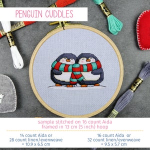 May include: Cross stitch pattern of two penguins wearing red and teal scarves, stitched on 16 count Aida fabric and framed in a 5 inch hoop. The finished piece measures 10.9 inches by 6.5 inches.