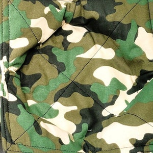 May include: Two green, brown and white camouflage fabric pot holders. The pot holders are quilted and have a square shape.