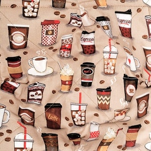 May include: Two brown quilted pot holders with a coffee cup and coffee bean pattern. The pot holders are made of fabric and have a quilted design.