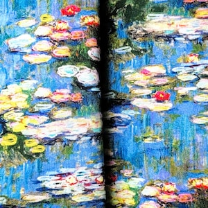 May include: A set of accessories featuring a water lilies design. The set includes a wrist strap with a metal clasp and a case. The fabric has a blue background with colorful water lilies in shades of red, yellow, and white.