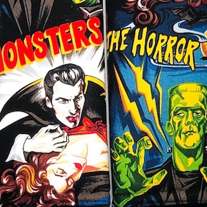 May include: A blue, black, and red fabric wristlet and two matching fabric cases. The cases feature vintage horror movie poster art with the words "MONSTERS" and "THE HORROR". The wristlet has a silver-colored metal ring.