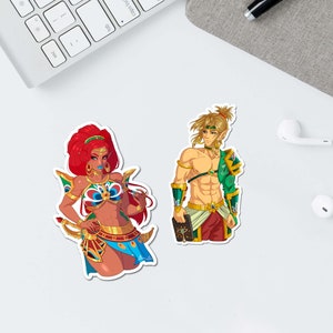 May include: Two stickers featuring cartoon characters. One sticker depicts a woman with red hair, wearing a blue and gold outfit, holding a bow and arrow. The other sticker shows a man with blonde hair, wearing a green and gold outfit, holding a book.