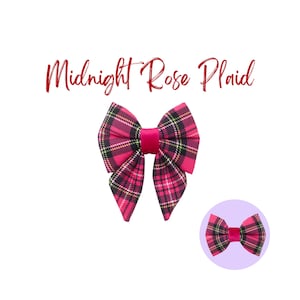 Könnte beinhalten: Eine rosa und schwarze Karobinde mit einem roten Samtmittelteil. Die Schleife ist in einer klassischen Schleifenform gebunden und hat an jeder Seite ein spitzes Ende. Der Text "Midnight Rose Plaid" steht über der Schleife.