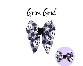 May include: A purple and black bow with a skull and crossbones pattern. The bow has a black velvet center and pink stars.