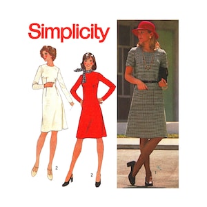 May include: Simplicity sewing pattern for a dress with three different styles. The pattern shows a white dress, a red dress, and a black and white checkered dress. The model wearing the black and white dress is also wearing a red hat.