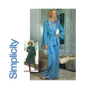May include: A blue trouser suit with a long, flowing skirt and a matching jacket. The jacket has a V-neckline and a belt. The model is wearing a pearl necklace and a small flower pin.