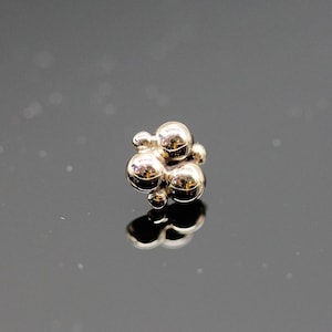 May include: A cluster of five gold-colored spheres, each with a smooth, rounded surface, forming a unique and abstract design.