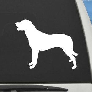 May include: White vinyl decal of a dog silhouette, applied to the rear window of a vehicle. The dog is depicted in a side profile, with its head raised and mouth slightly open. The decal is a simple, clean design.