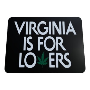 Puede incluir: Una pegatina rectangular negra con texto blanco que dice VIRGINIA IS FOR LOVERS. La letra V en la palabra LOVERS está reemplazada por un gráfico de hoja de cannabis verde. La pegatina tiene esquinas redondeadas y una superficie lisa y plana.