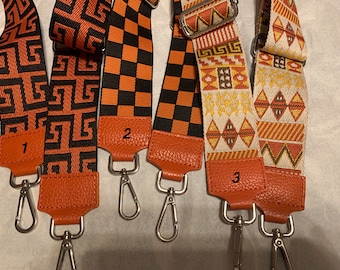 May include: Three orange and black patterned fabric straps with leather ends and silver clasps. The straps are numbered 1, 2, and 3.