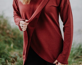 Puede incluir: Una camisa de manga larga de color granate con cuello de pico y un corte holgado. La camisa está hecha de una tela suave y cómoda y tiene un estilo casual y sin esfuerzo.