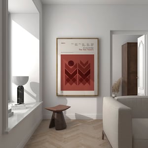 Può includere: Un poster incorniciato con un design minimalista che presenta uno sfondo rosso e forme geometriche. Il poster è intitolato "The Two Towers" ed è un riferimento alla serie di libri "Il Signore degli Anelli".