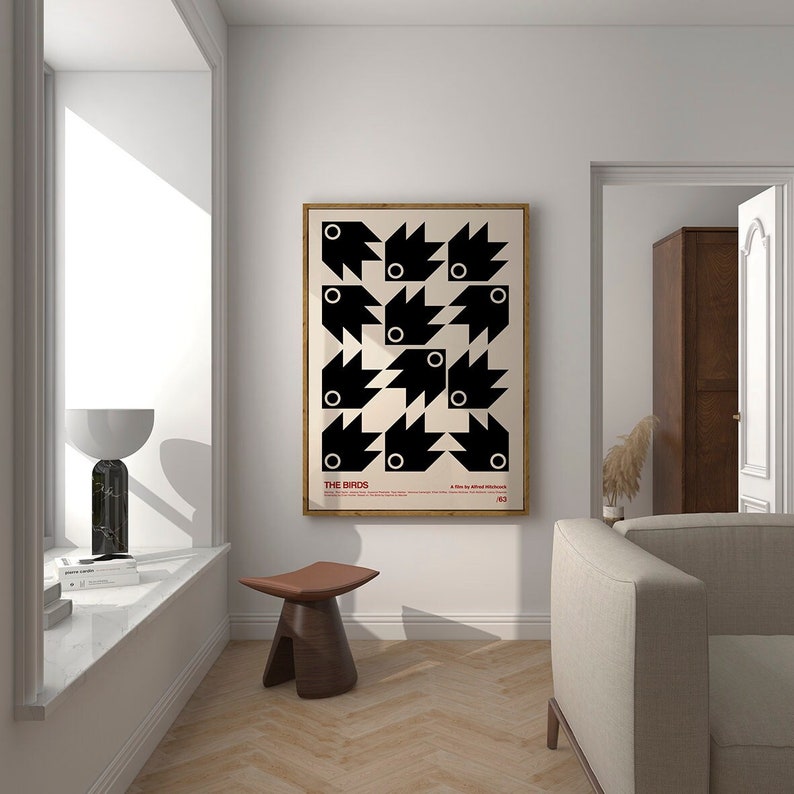 May include: A black and white poster featuring a geometric design of birds. The poster is framed in wood and has the title "THE BIRDS" in red text.