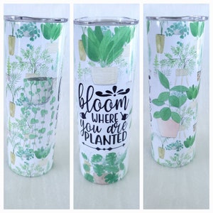 May include: White stainless steel tumbler with a green and white floral pattern and the text "bloom where you are planted".