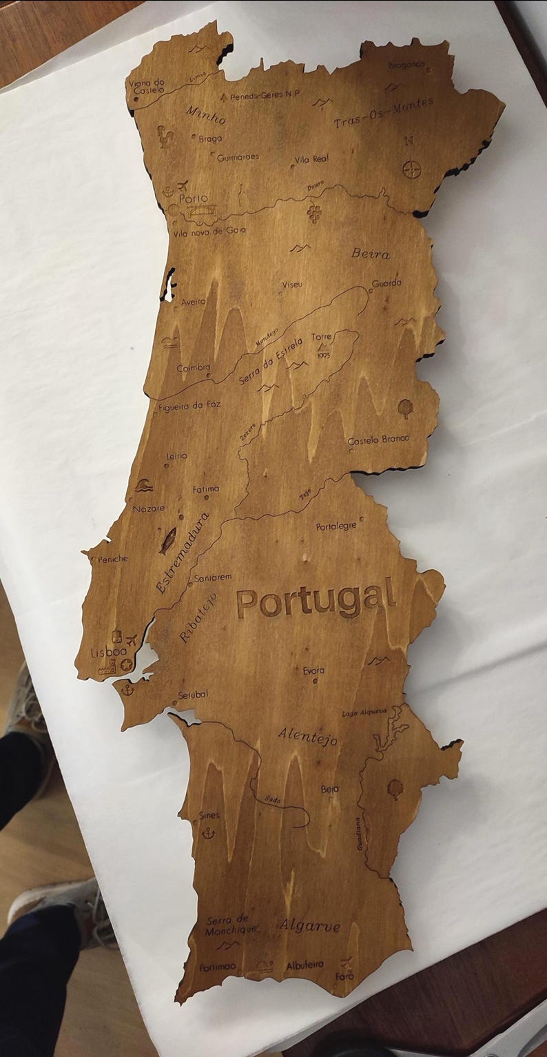 May include: Wooden map of Portugal, laser-cut with detailed geographical features and city names. The map is made of light brown wood, with the country's name prominently displayed. A decorative piece for home decor.