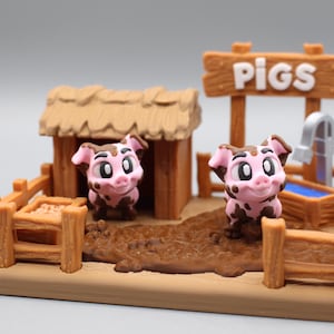 May include: A miniature farm scene featuring two pink pigs with brown spots, a wooden pig pen, a small hut, and a sign that reads "PIGS". The scene includes a water trough and a mud puddle.