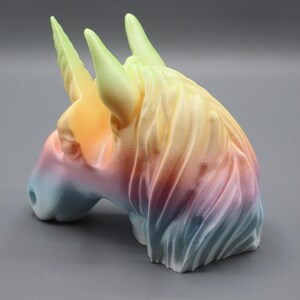 a colorful ceramic horse head on a gray surface
