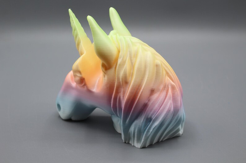 a colorful ceramic horse head on a gray surface