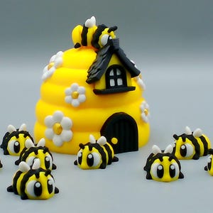 May include: A whimsical yellow beehive with a black roof and door, adorned with white daisy accents. Several cartoon bees with black and yellow stripes surround the hive, creating a playful scene.