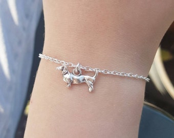 May include: A silver chain bracelet with a small silver dachshund charm.
