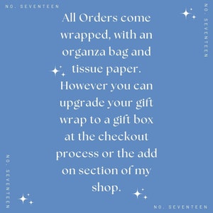 May include: A blue background with white text that reads "All Orders come wrapped, with an organza bag and tissue paper. However you can upgrade your gift wrap to a gift box at the checkout process or the add on section of my shop."