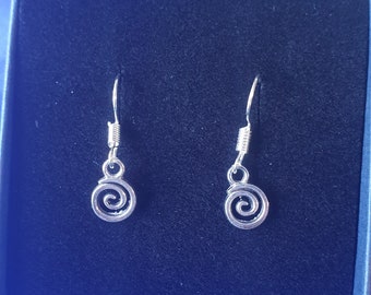 May include: A pair of silver dangle earrings with a spiral design. The earrings are on a blue background.