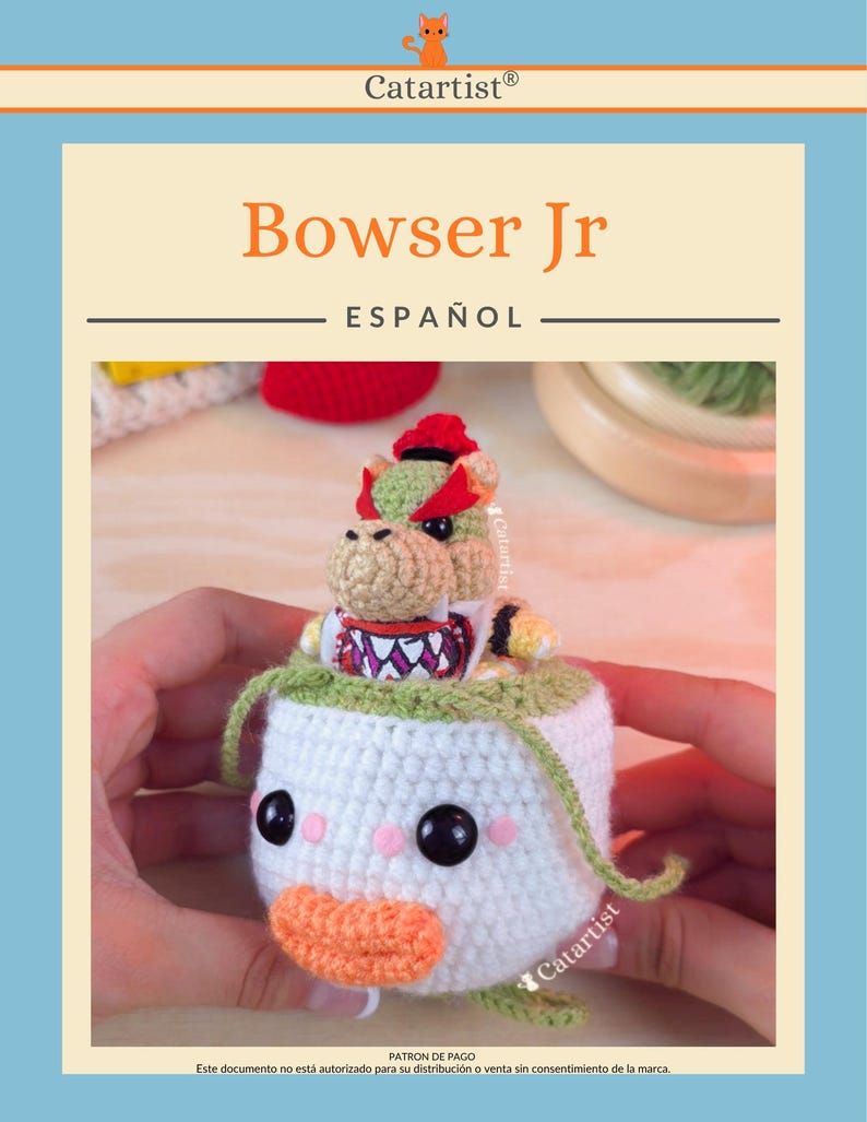 Op de afbeelding: Een gehaakte Bowser Jr. figuur, met een witte body, groene en oranje afwerking, zwarte ogen, roze wangen en een oranje snavel. De teksten "Bowser Jr" en "ESPA&Ntilde;OL" zijn zichtbaar. Het Catartist-logo is ook aanwezig.