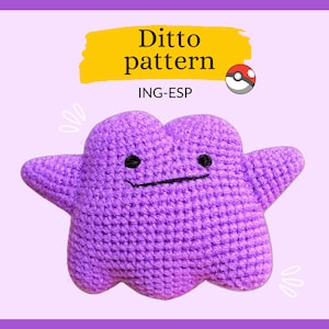 Könnte beinhalten: Lilafarbener gehäkelter Plüsch-Ditto mit schwarzen Augen und einem Lächeln. Das Spielzeug befindet sich auf einem rosa Hintergrund mit dem Text "Ditto pattern ING-ESP" und einem Pokéball.