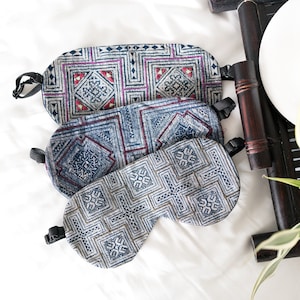 May include: Three blue and white patterned sleep masks with geometric designs. The masks are made of fabric and have elastic straps.