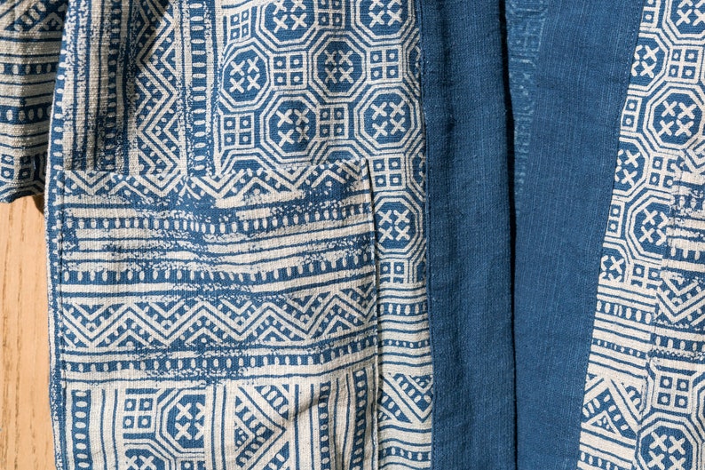 May include: A blue and white patterned fabric with a geometric design. The fabric has a subtle texture and a slightly faded look.