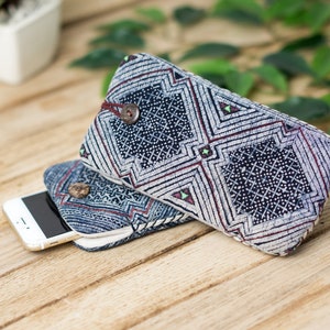 May include: Two blue and white patterned fabric phone cases with a white background and a geometric design. The cases are stacked on top of each other with a white smartphone inside the top case.
