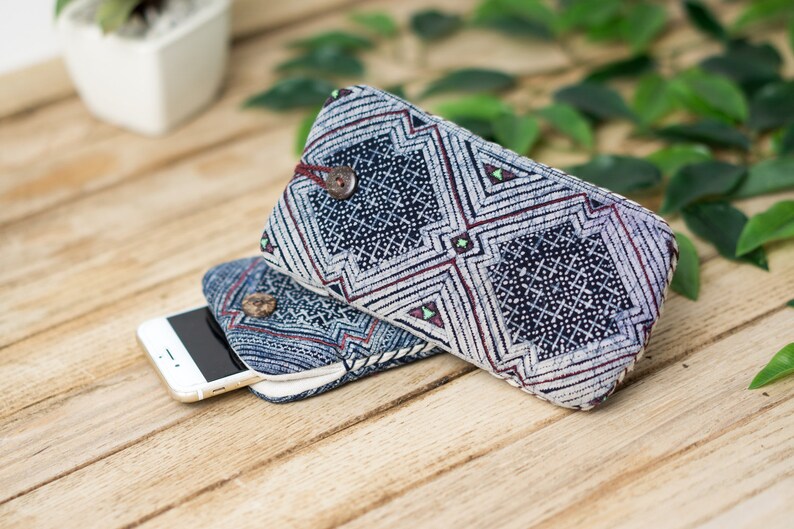 May include: Two blue and white patterned fabric phone cases with a white background and a geometric design. The cases are stacked on top of each other with a white smartphone inside the top case.