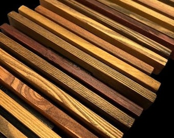 May include: A collection of wooden slats, each with a unique grain pattern and color variation, ranging from light brown to dark reddish brown. The slats are arranged in a staggered pattern, creating a visually interesting texture.