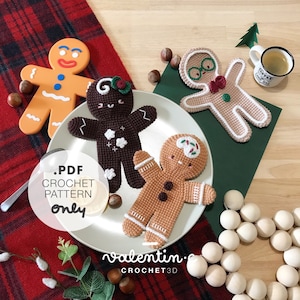 Peut inclure: Quatre personnages en crochet en pain d'épices, un brun, un beige, un brun clair et un rouge et blanc, sur une assiette blanche avec un fond à carreaux rouge et noir. Le texte sur l'assiette est "valentin.e CROCHET3D".