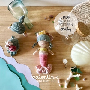 Peut inclure: Une poupée sirène en crochet avec une queue rose, un haut jaune et une couronne verte et dorée. La poupée est assise sur une surface en bois avec des coquillages et d'autres décorations sur le thème de la plage. Le texte "PDF CROCHET PATTERN only" est visible sur l'image. Le texte "valentin.c CROCHET3D" est également visible sur l'image.