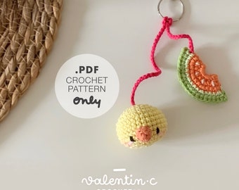 May include: A handmade crochet keychain featuring a yellow chick and a watermelon slice. The chick has a pink beak and cheeks. The watermelon slice is green, orange, and white. The keychain is attached to a silver clasp. The text on the image says ".PDF CROCHET PATTERN only".