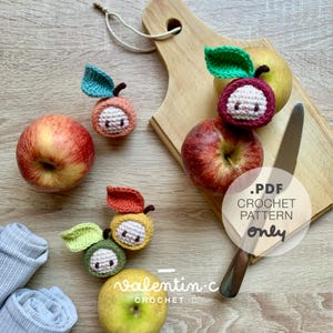 Peut inclure: Patron de crochet pour réaliser d'adorables peluches en forme de pomme. Le patron est disponible en téléchargement PDF uniquement. L'image montre quatre pommes au crochet de différentes couleurs, ainsi que de vraies pommes.