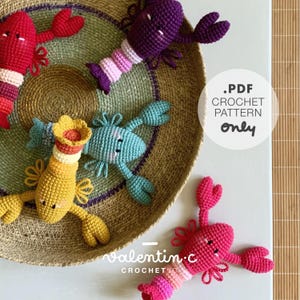 May include: A collection of colorful, crocheted lobster toys in red, purple, yellow, and blue, with striped tails and detailed claws. The toys are arranged in a woven basket. The image includes the text ".PDF CROCHET PATTERN only" and "Valentin.c CROCHET".