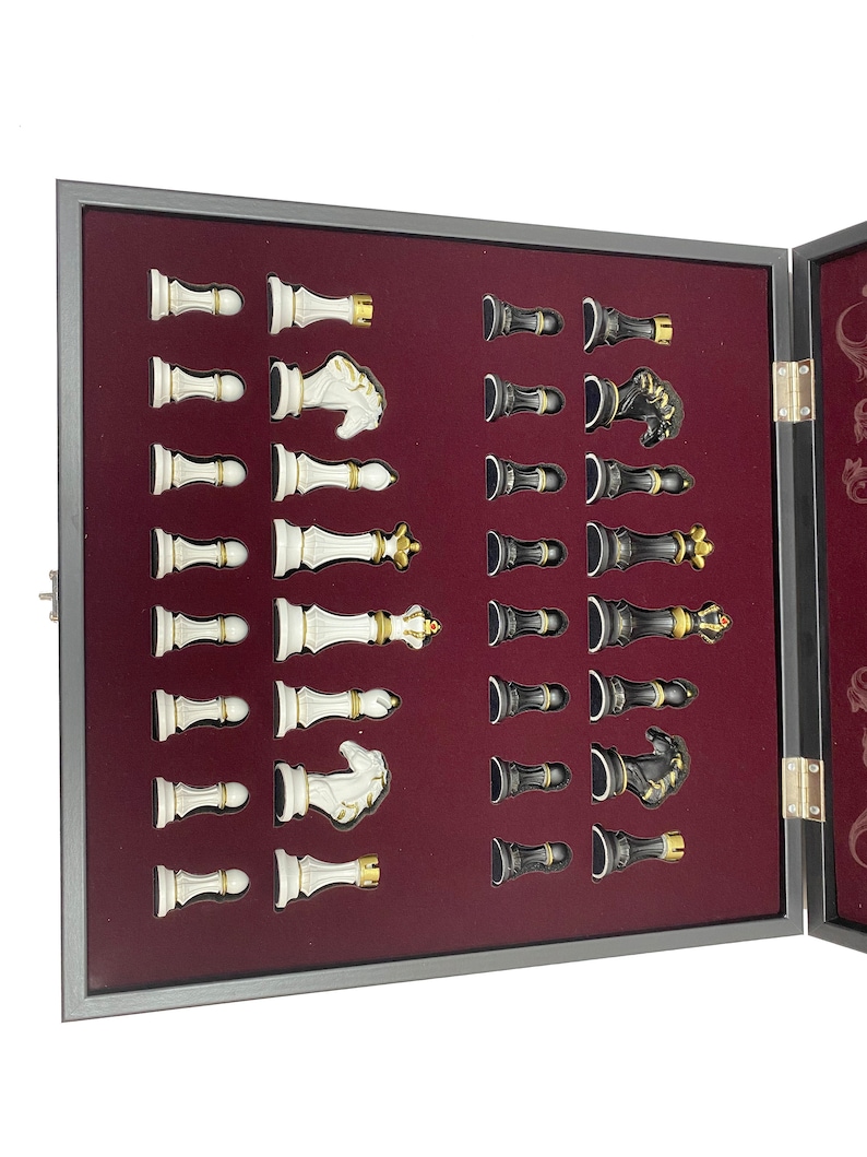 May include: A wooden chessboard set with black and white chess pieces. The pieces are arranged in their starting positions in the box. The box is lined with red felt.